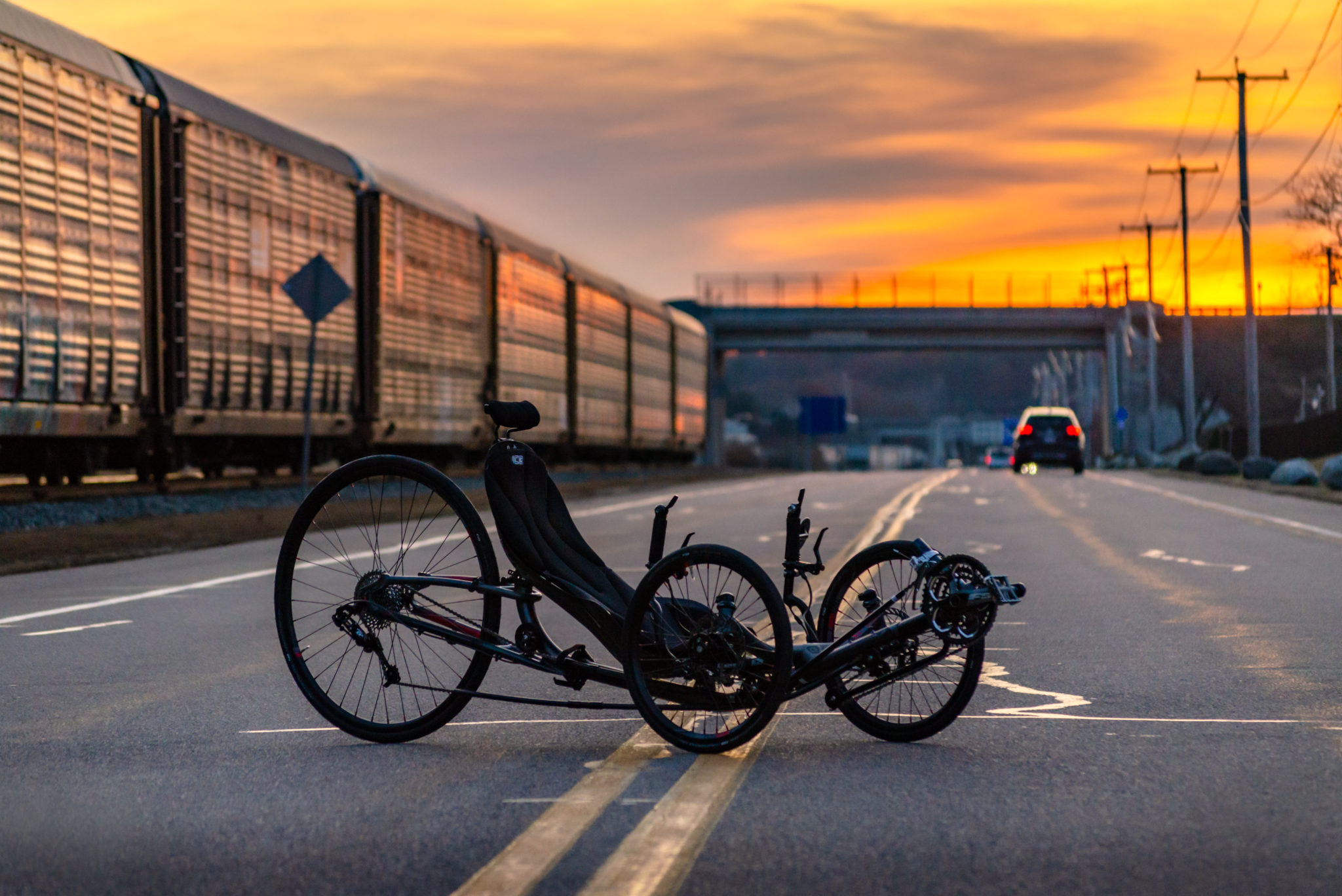 A black Ice Trike parked in the street at sunset