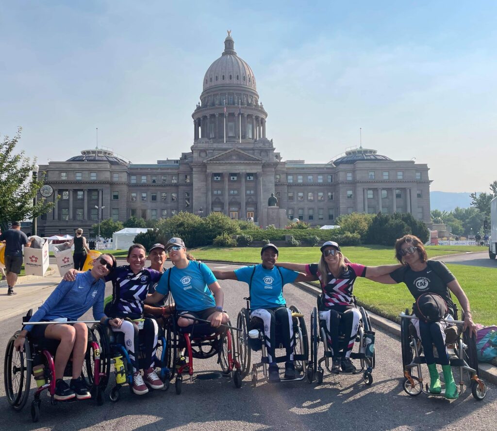 6 women in wheelchairs pose in front of a white marble building in Boise, Idaho